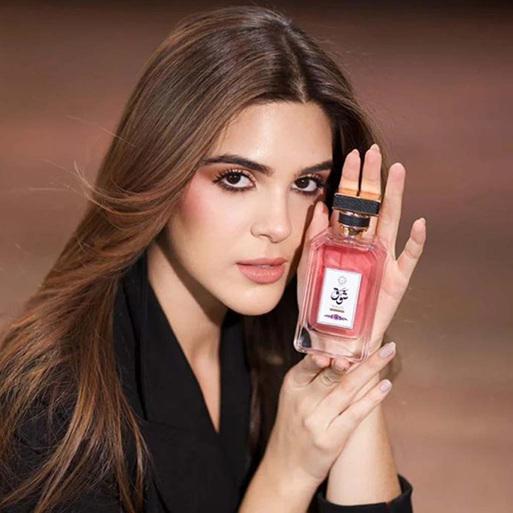 Woman holding a pink abyat_shouq_perfume bottle imperial aroma